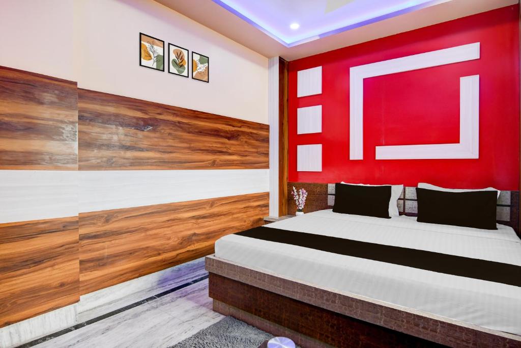 a bedroom with a bed with a red wall at Super Collection O New Jalpaiguri Railway Station Formerly Prince Lodge in Siliguri