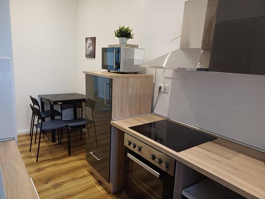 eine Küche mit Herd oberer Ofen neben einem Tisch in der Unterkunft Wohnung in Köln 3B in Köln