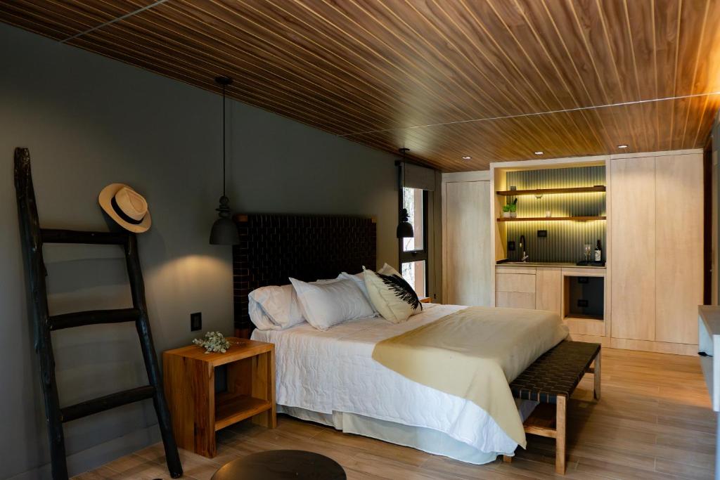 a bedroom with a large bed with a wooden ceiling at Lun Lodges in Ciudad Lujan de Cuyo