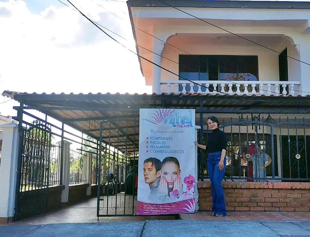 a woman standing next to a sign in front of a building at Casa del Pino in Popayan