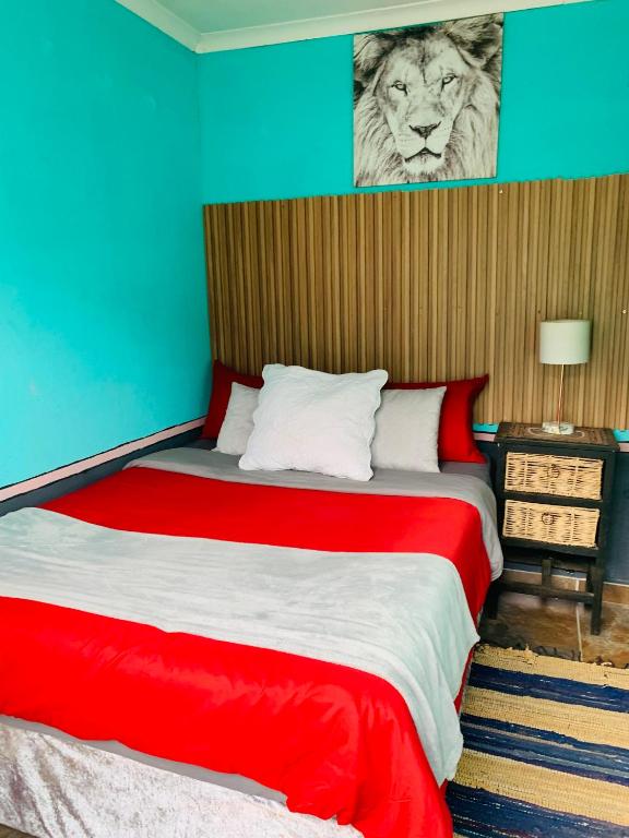 a bedroom with a bed with a tiger picture on the wall at Ewakanda Backpackers in Vereeniging