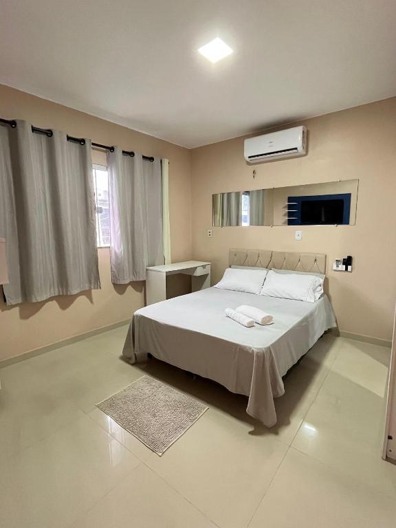 une chambre avec un lit blanc et une fenêtre dans l'établissement Acomodação para COP30, à Belém