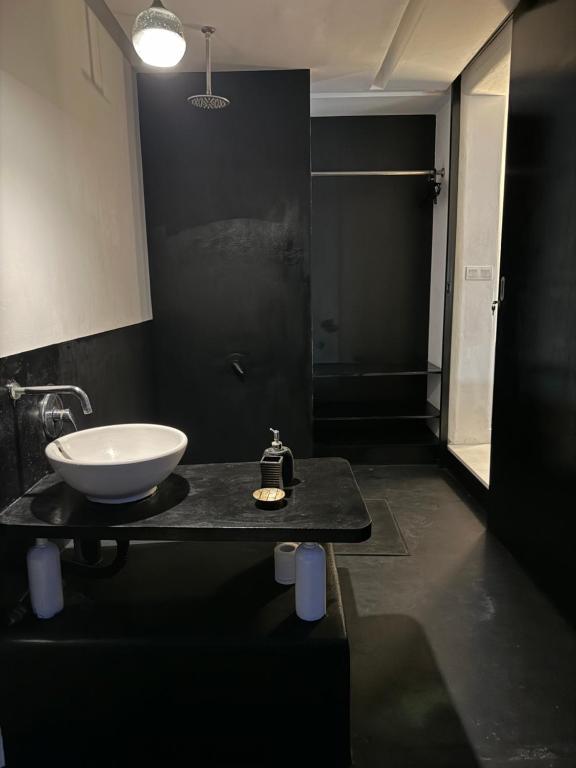 a bathroom with a white sink on a black counter at Serenity Room at Villa Love in Seminyak
