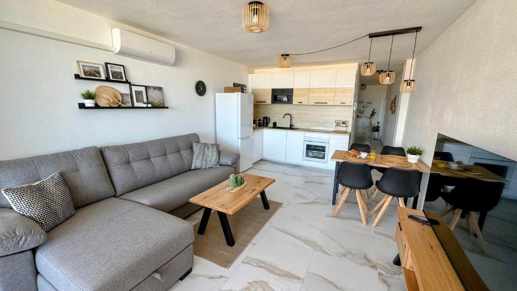 a living room with a couch and a table and a kitchen at Skyview Apartment in Adeje