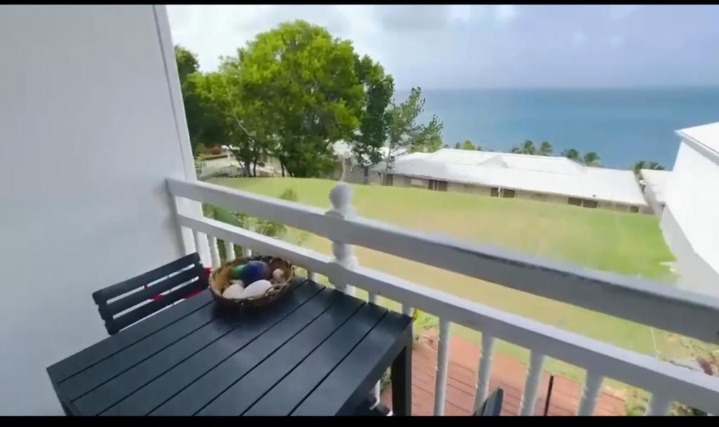 un pájaro sentado en un banco en un balcón en Pause tropicale, en Le Diamant