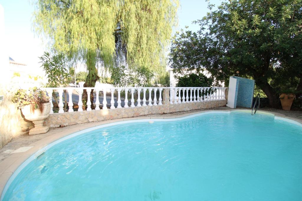 a large blue swimming pool with a fence at Alcaria Pool House in Altura