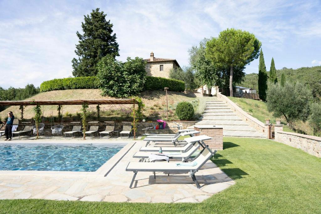 a pool with lounge chairs next to a house at Stone Villa Overlooking Panicale Vineyards in Panicale