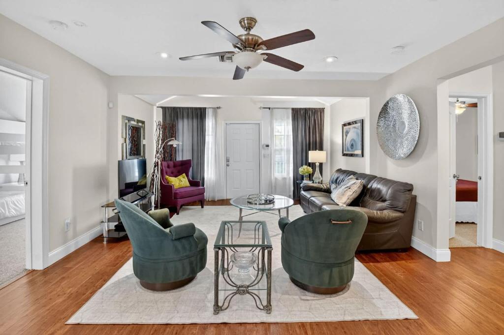 een woonkamer met een bank en stoelen en een plafondventilator bij Southern Comfort - For 6 Guests in Gulf Stream