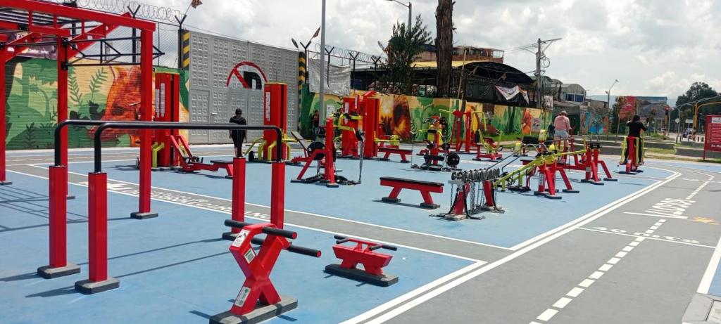 波哥大Habitación cerca del aeropuerto el dorado的一个健身房，里面摆放着红色的器材，球场是蓝色的。