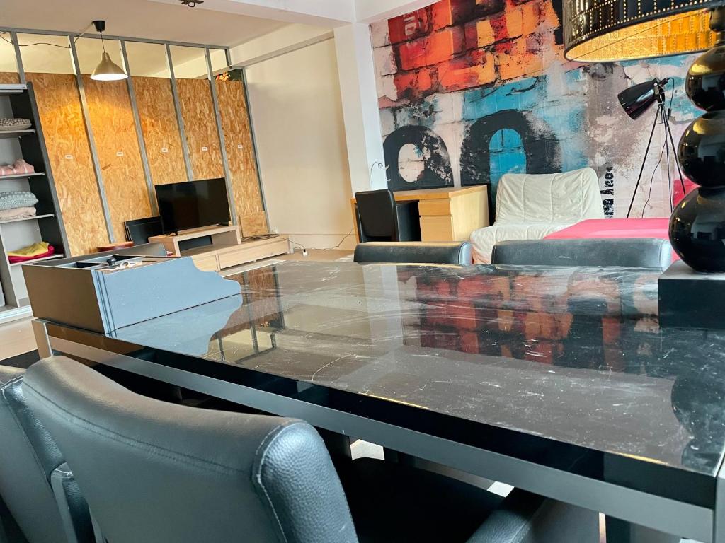 a living room with a large glass table and chairs at Green River Loft in Beersel