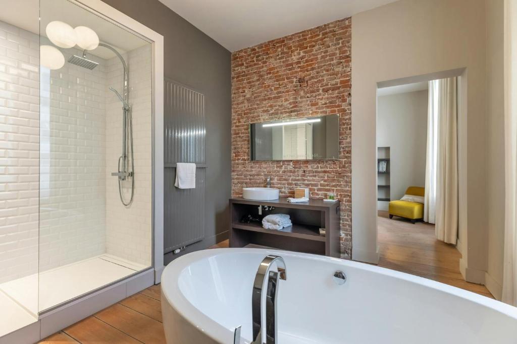 een badkamer met een bad en een douche bij DeuxHommes B&B Massage&Spa in Hasselt