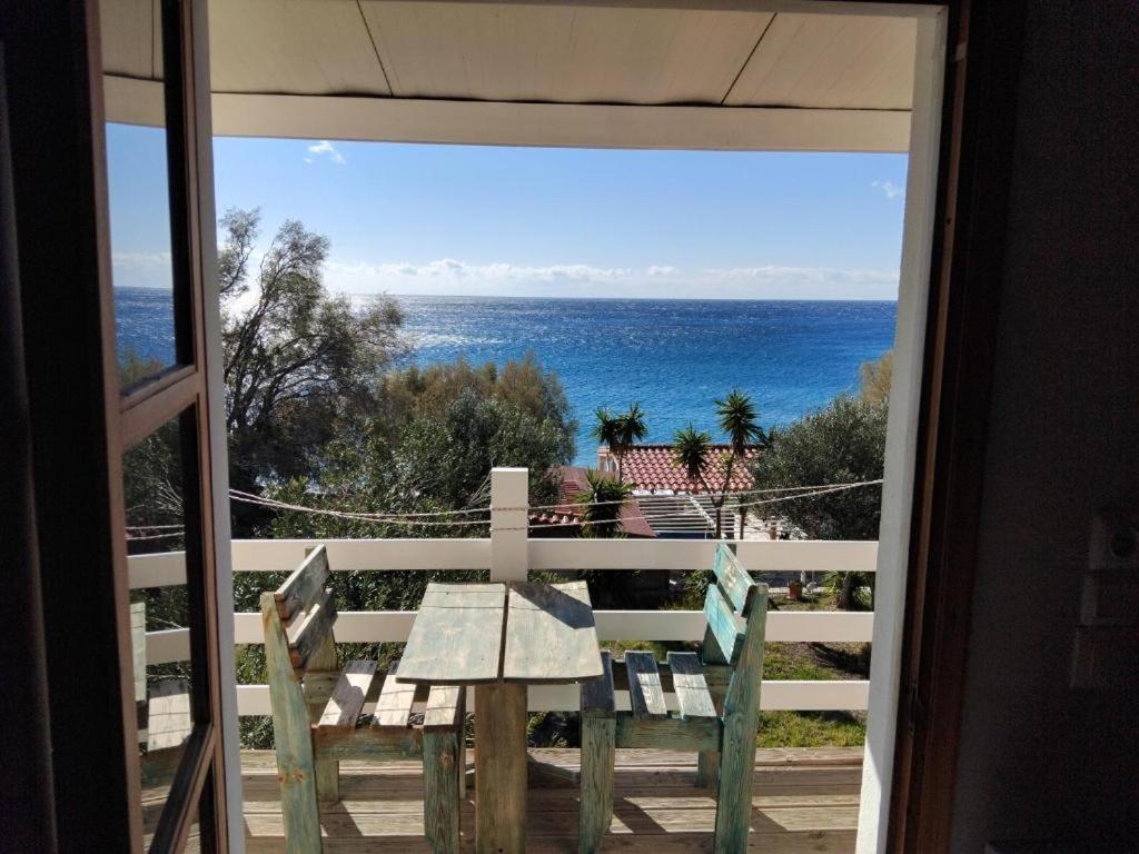 a view of the ocean from a balcony with a table at Apartments Petrakis Beach in Lentas