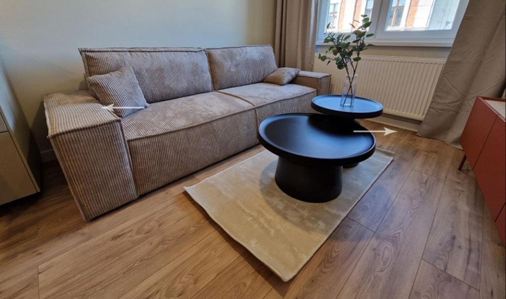 a living room with a couch and a table at Apartament Podniebny z Windą in Kluczbork