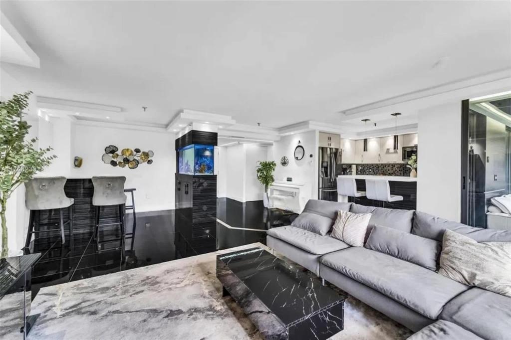 ein Wohnzimmer mit Couch und Küche in der Unterkunft Modern Condo with Private Primary Suite in Ives Estates