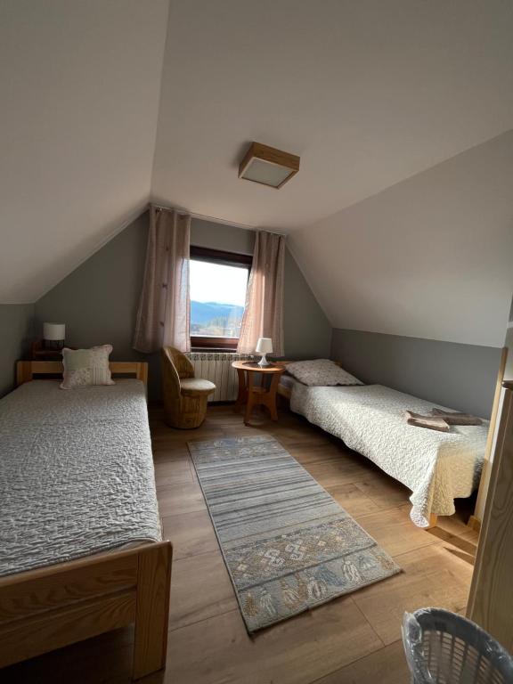 a bedroom with two beds and a window at Pod Cisowcem in Sromowce Wyżne