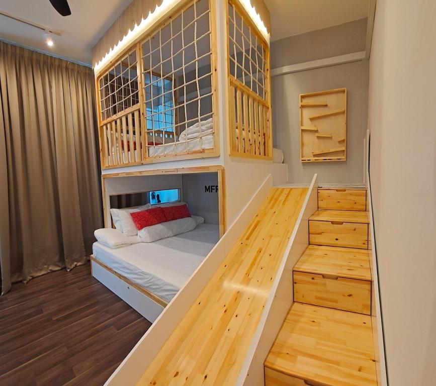 une chambre avec un lit superposé et un escalier dans l'établissement Playground Studio in Kuantan, à Kuantan