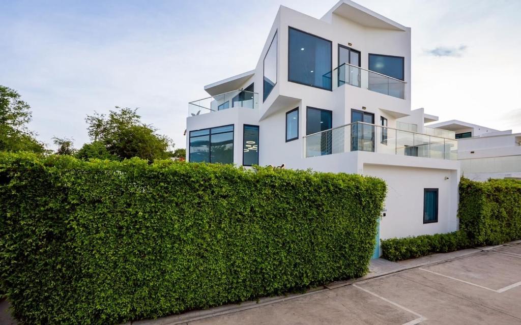 a white house with a hedge in front of it at Wonderland Sapphire 8 Bedroom Luxury Villa in Pattaya South