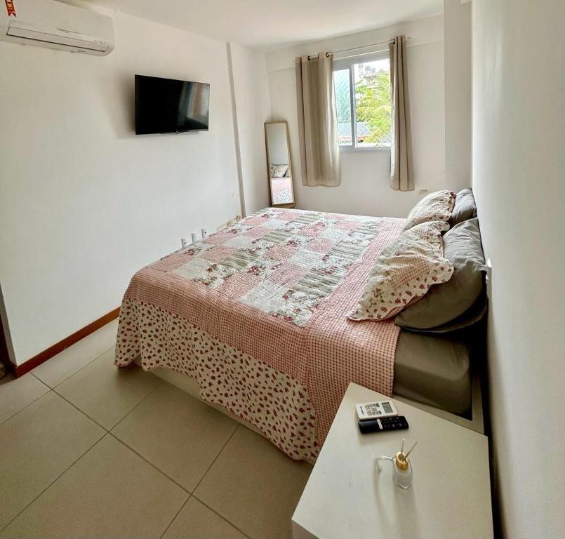 een kleine slaapkamer met een bed en een tafel bij Ap Villa Toscana in Ilhéus