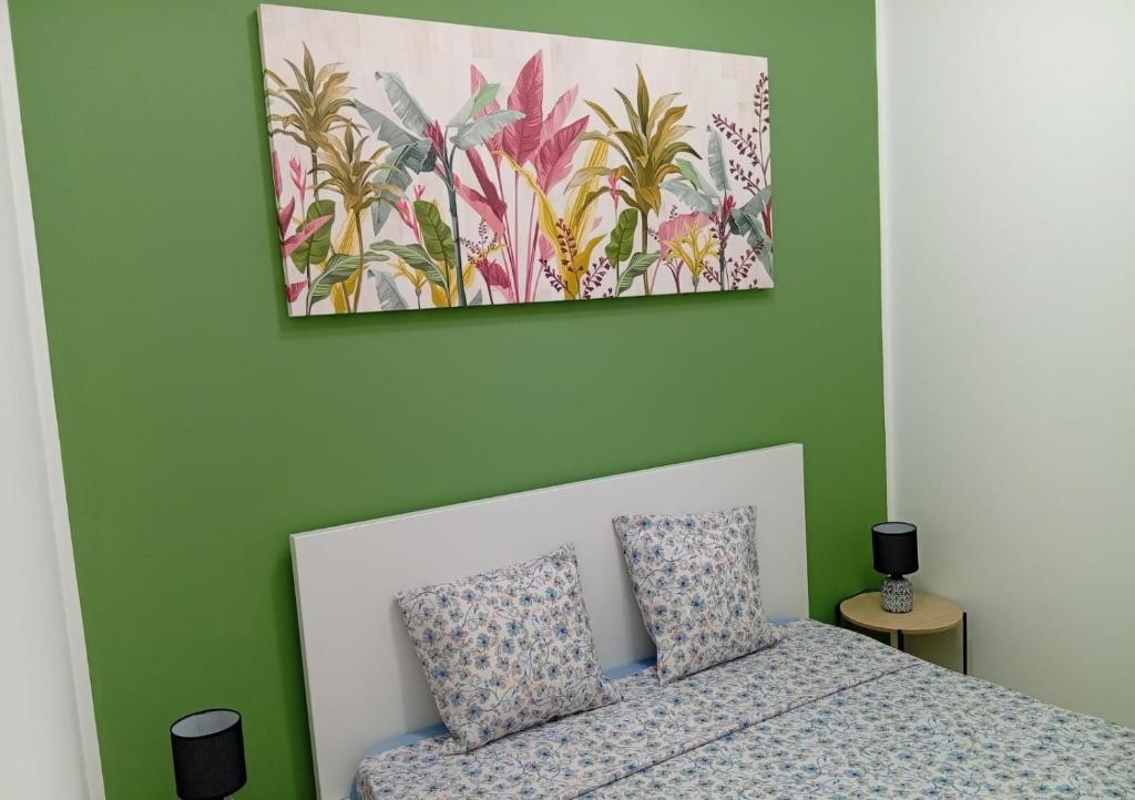 a bedroom with a bed and a painting on the wall at Sicilia Bedda Casa Vacanze in Lascari