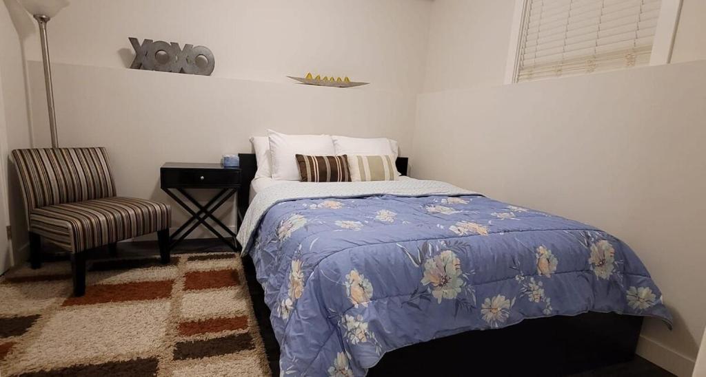 ein Schlafzimmer mit Bett, Stuhl und Schreibtisch in der Unterkunft MegaVille in Saskatoon