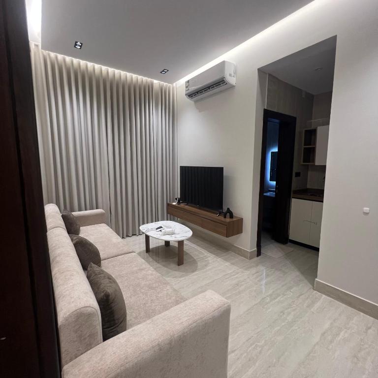 Una sala de estar con un sofá y un televisor. en سويت ضيافة البرج, en Al Kharj