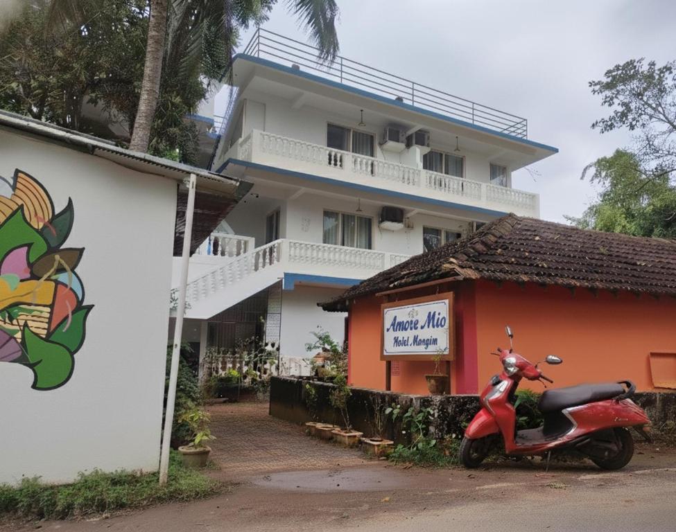 a scooter parked in front of a building at Hotel Amore Mio Morjim in Morjim