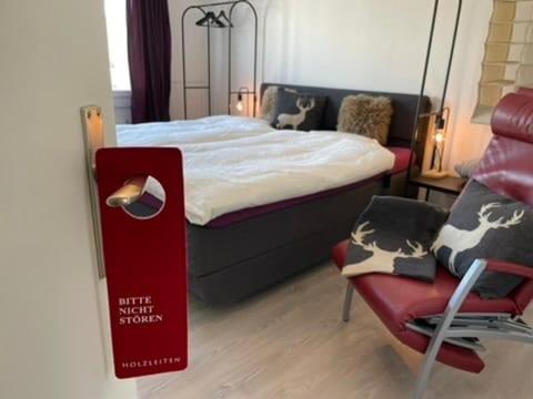 Un pequeño dormitorio con una cama y una silla. en Relax Paradise in Bad Zurzach, en Bad Zurzach