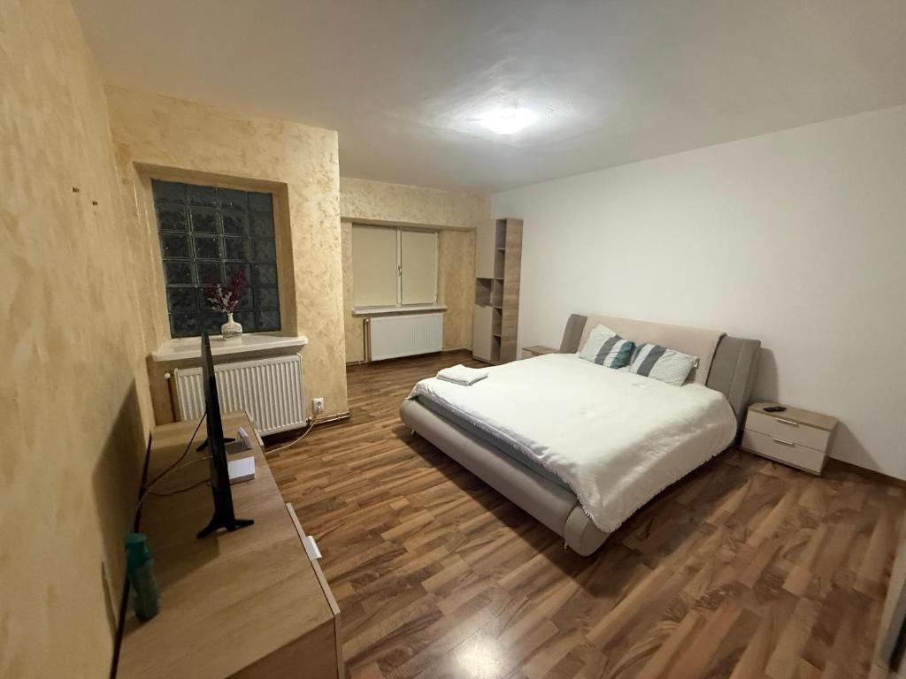 a bedroom with a large bed and a wooden floor at Cozy apartment in Craiova