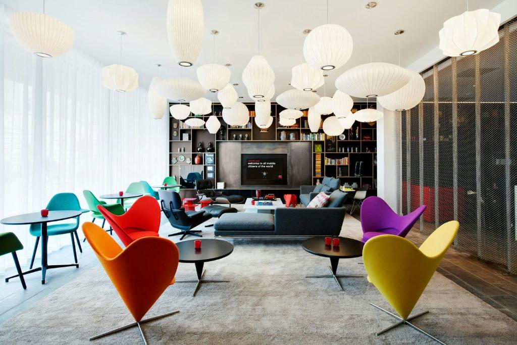 a living room with colorful chairs and a couch at citizenM Tower of London in London