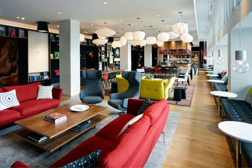 Una sala de estar con sofás rojos y una mesa. en citizenM Zürich, en Zúrich
