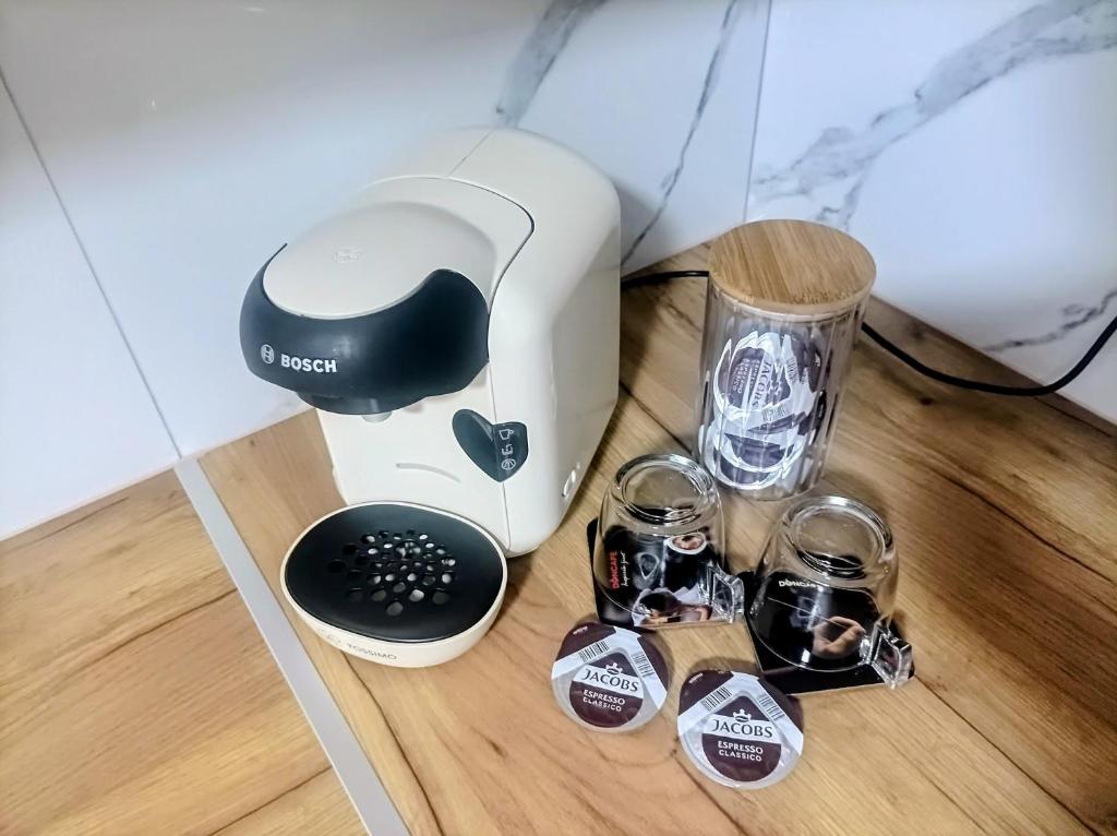 a blender and two glasses on a wooden table at INKOGNITO Centar 39 in Brčko