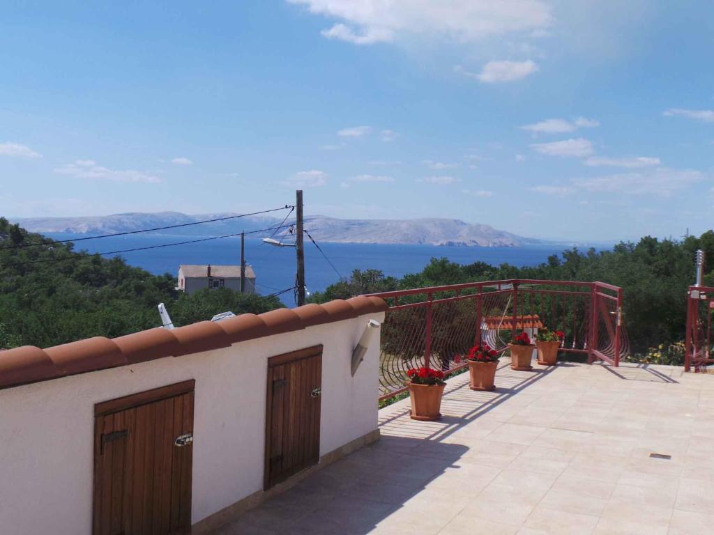 a balcony with potted plants and a view of the water at Apartments in Sveti Juraj 27785 in Burnjak
