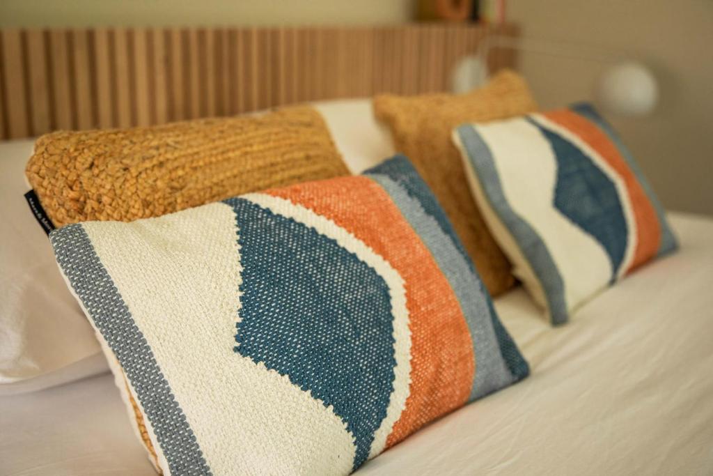 a group of pillows on a bed in a room at Chambre d Amis in Lokeren