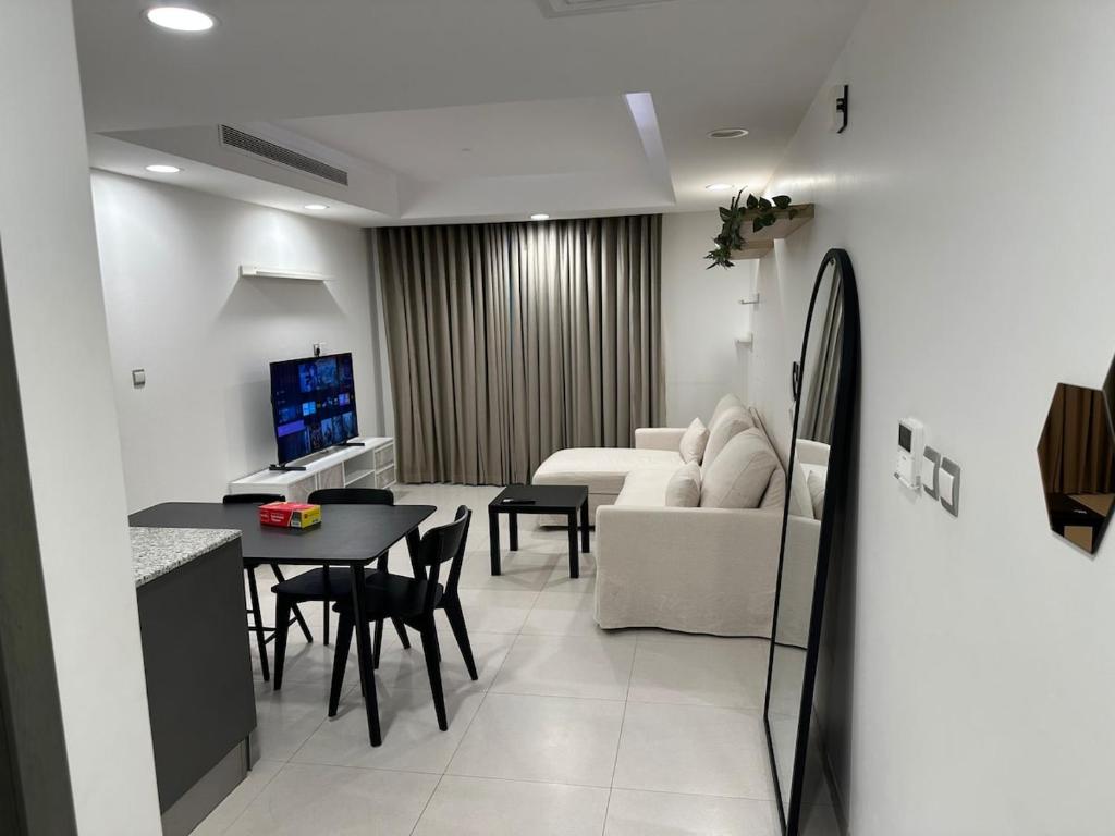a kitchen and living room with a table and a couch at Central Bliss Apartment in Muscat