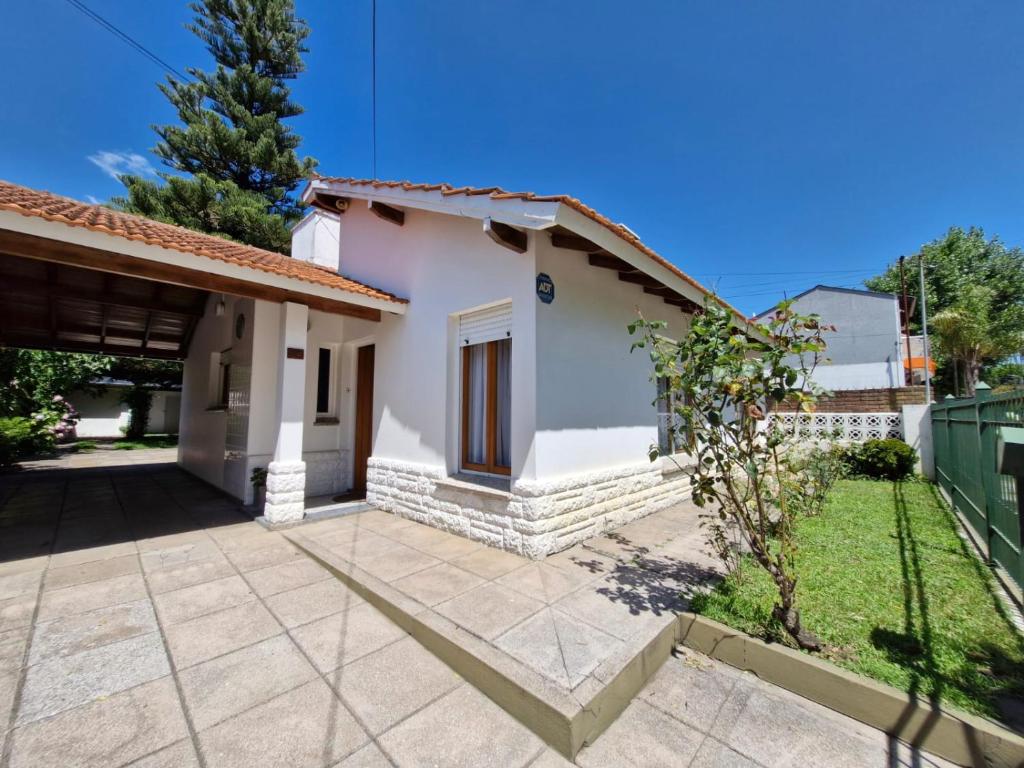 ein kleines weißes Haus mit einem Innenhof in der Unterkunft Casa Castelli in Mar de Ajó
