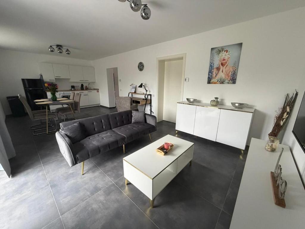 a living room with a black couch and a table at Mira Suites 1 in Schwalbach