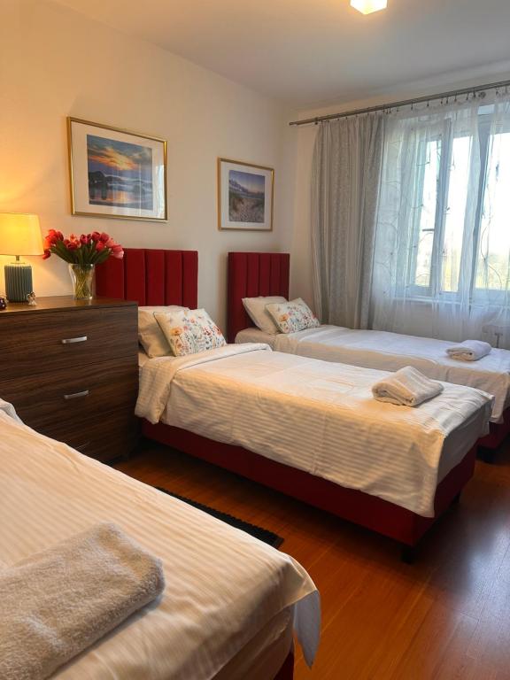 a bedroom with three beds and a dresser and a window at Apartament Diana - Traugutta Wrocław in Wrocław