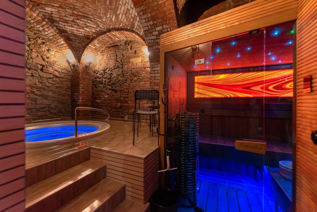 a bath room with a tub and a swimming pool at Rezidence Znojmo SPA Privat wellness in Znojmo