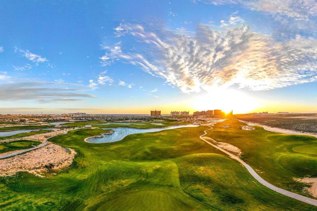 an aerial view of a golf course with the sun setting at 1BR 1BA Ocean View Las Palomas Phase 1 Bld Ruby in Puerto Peñasco