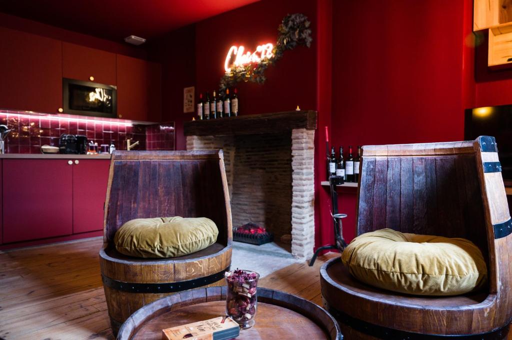 a wine tasting room with two chairs and a table at Chai numéro 12, une immersion au coeur du vin in Bergerac