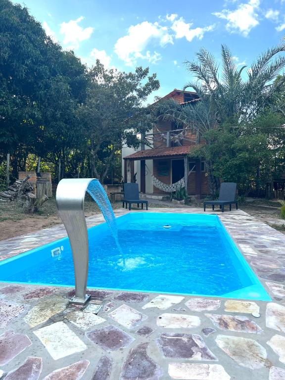 a pool with a water fountain in front of a house at Recanto Pitanga in Vale do Capao