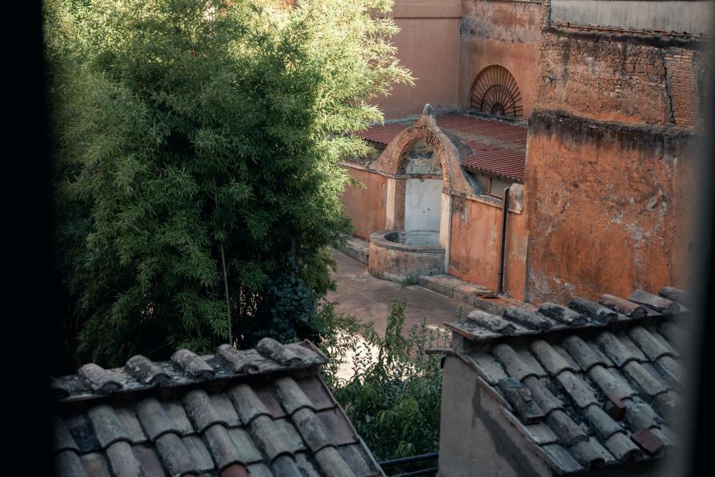 una vista di un vecchio edificio con un albero e dei tetti di House of Allora a Roma