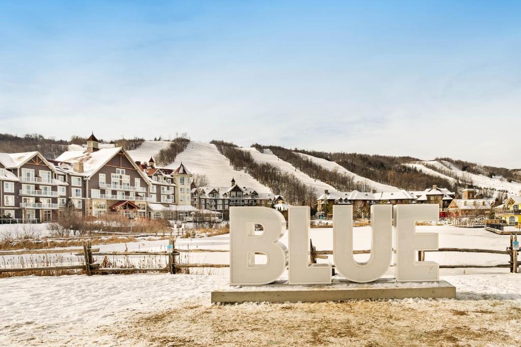 a sign in the snow in front of a village at Chateau Ridge in Blue Mountains