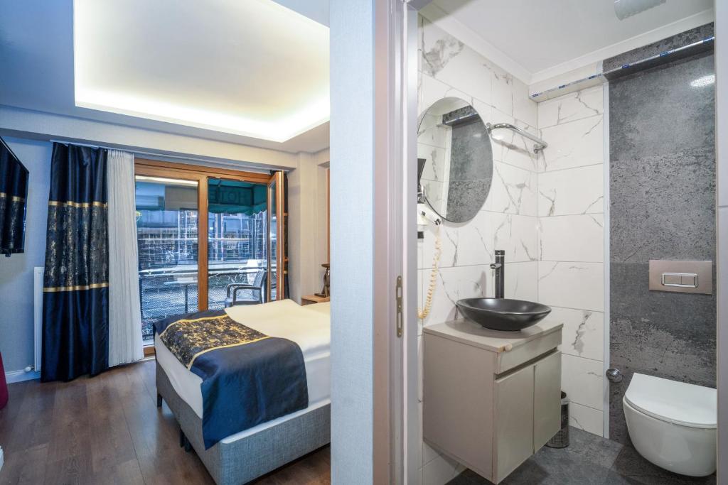 a bedroom with a bed and a bathroom with a sink at Hotel Martini in Istanbul