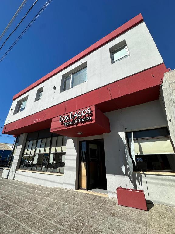 a red and white building with a sign on it at Los Lagos Hotel in Sarmiento