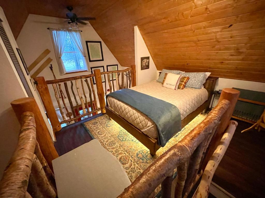 Un dormitorio con una cama en una cabaña de troncos en Kataluma Inn, Sandpoint, Idaho - Entire Cozy Cabin, Pet Friendly, en Sandpoint