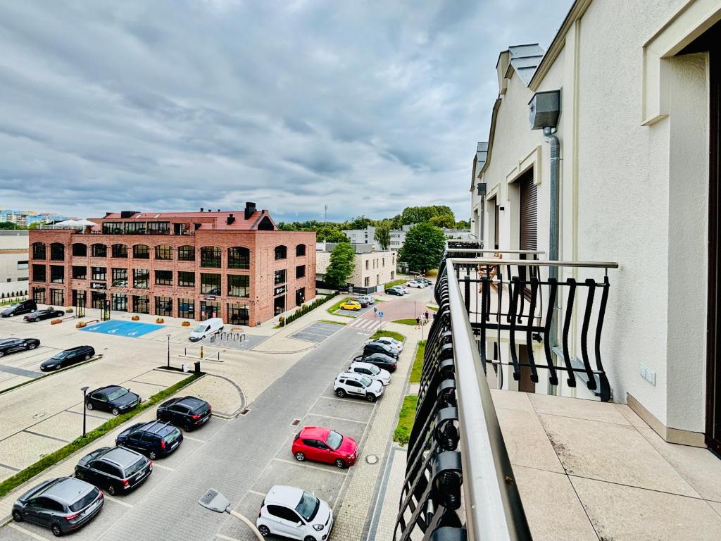 a city street with cars parked in a parking lot at Apartamenty przy Szpitalu na Bema in Lubin