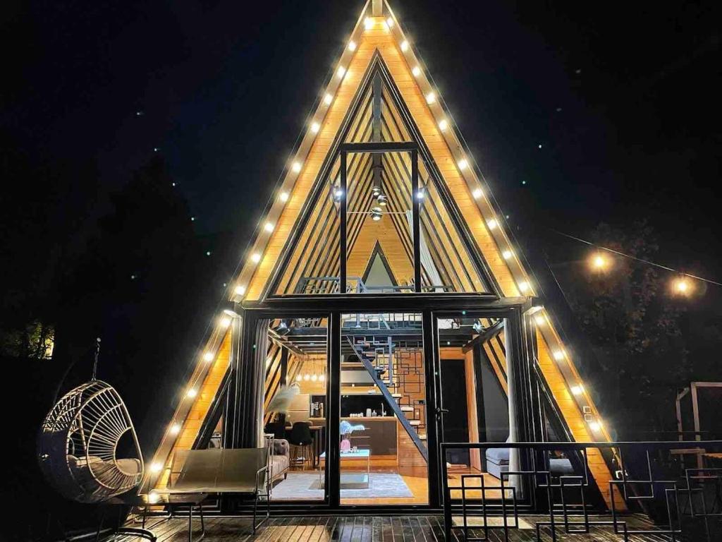 a large building with lights on it at night at A frame pool house in Ledinci