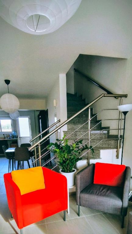 a living room with colorful furniture and a staircase at Harmonia Home in Paralimni