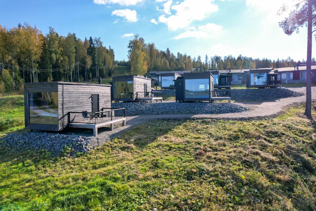 un gruppo di piccole case in un campo di Maisemasviitit Ellivuori Resort a Karkku